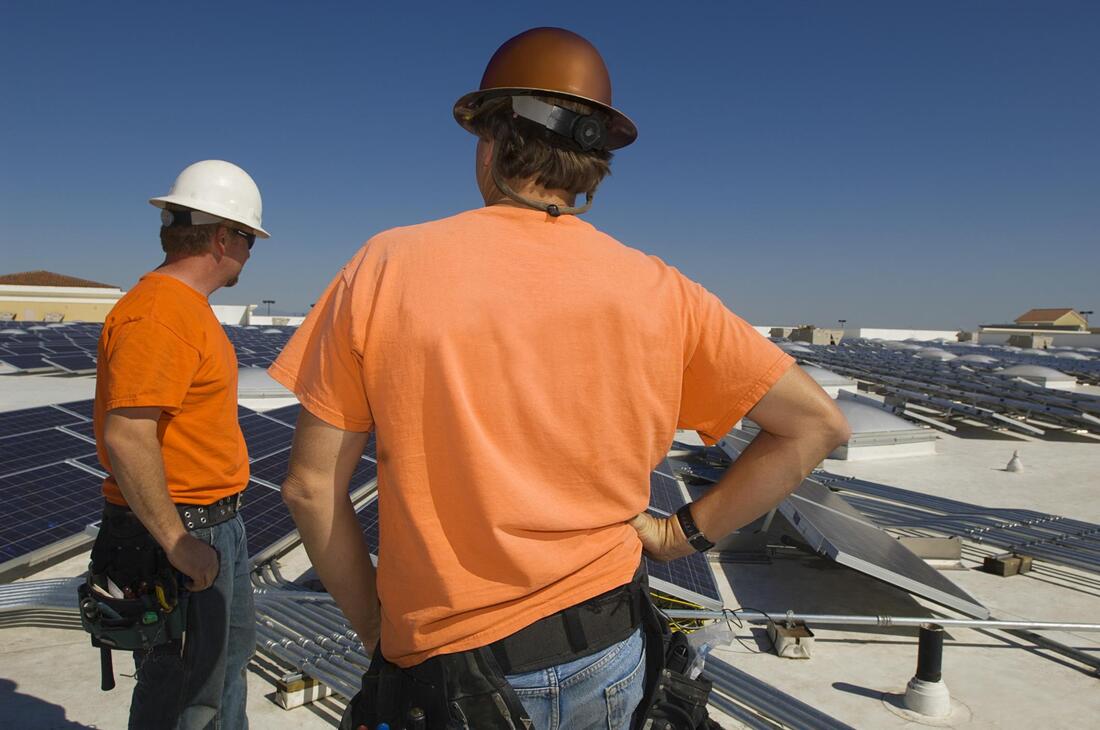 two workers inspecting the solar panels